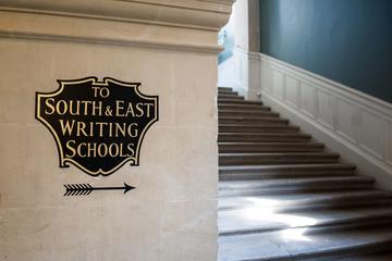 Sign pointing to a staircase inside the Exam Schools, reading 'To South & East Wright Schools'